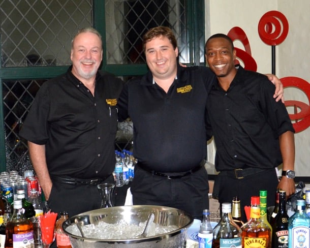 Three Bartenders Express bartenders in company blacks behind a party bar