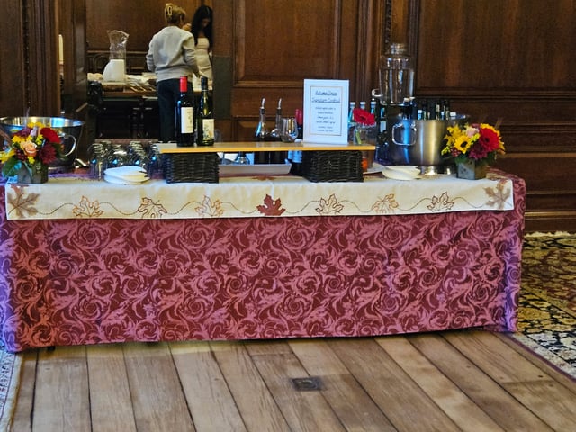 An autumn signature-cocktail table dressed with sunflowers in a paneled hall
