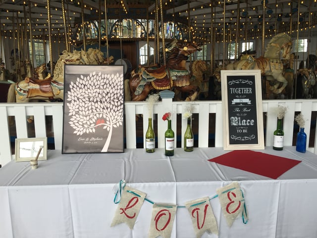 A wedding welcome table with wine and a LOVE banner
